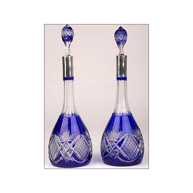 Pair of Bohemian crystal decanters with solid silver mouths.